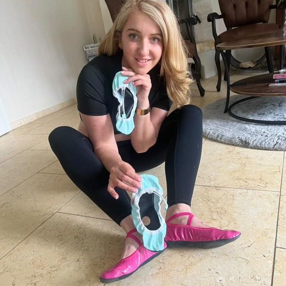 pink ballet Iwona unsere Produkttesterin der ersten Stunde in Sportkleidung zeigt Ballettschuhe in der Hand und trägt pinke Ballettschuhe.